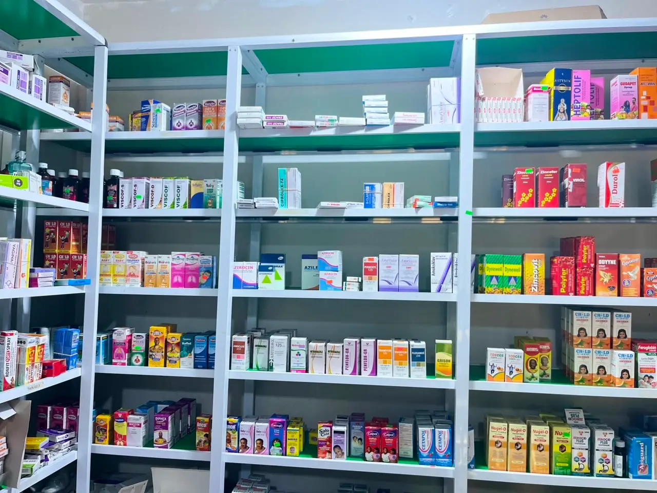 Antibiotics, cough syrups and general medicines on the shelves at Marisca Pharmacy.